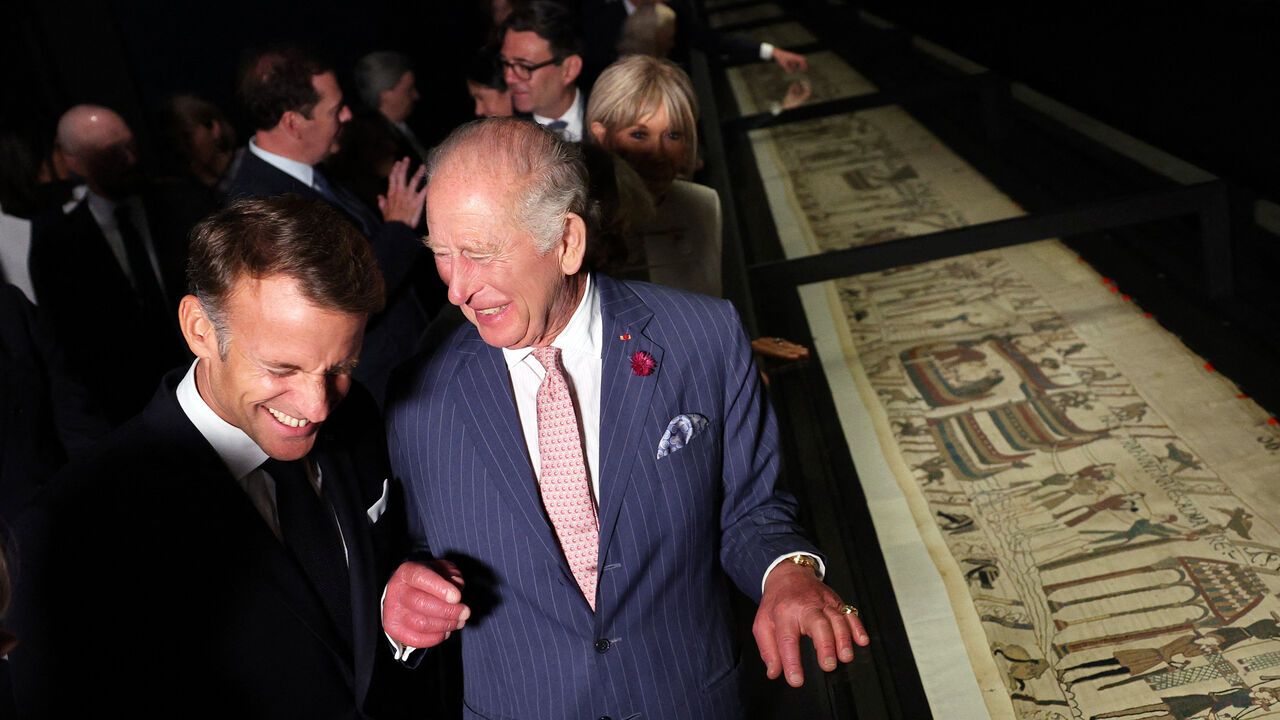 Britain's King Charles III and France's President Emmanuel Macron view sections of the Bayeux Tapestry.