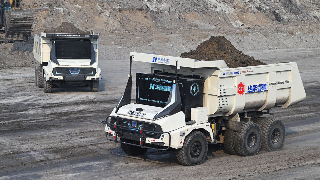 Unmanned mining trucks loaded with stripped soil and rock make their ways to the dumping site at the Yimin coal mine