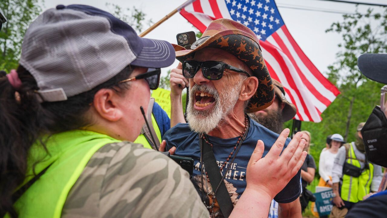 A pro-ICE counter-protester yells at an anti-ICE protester during a demonstration.
