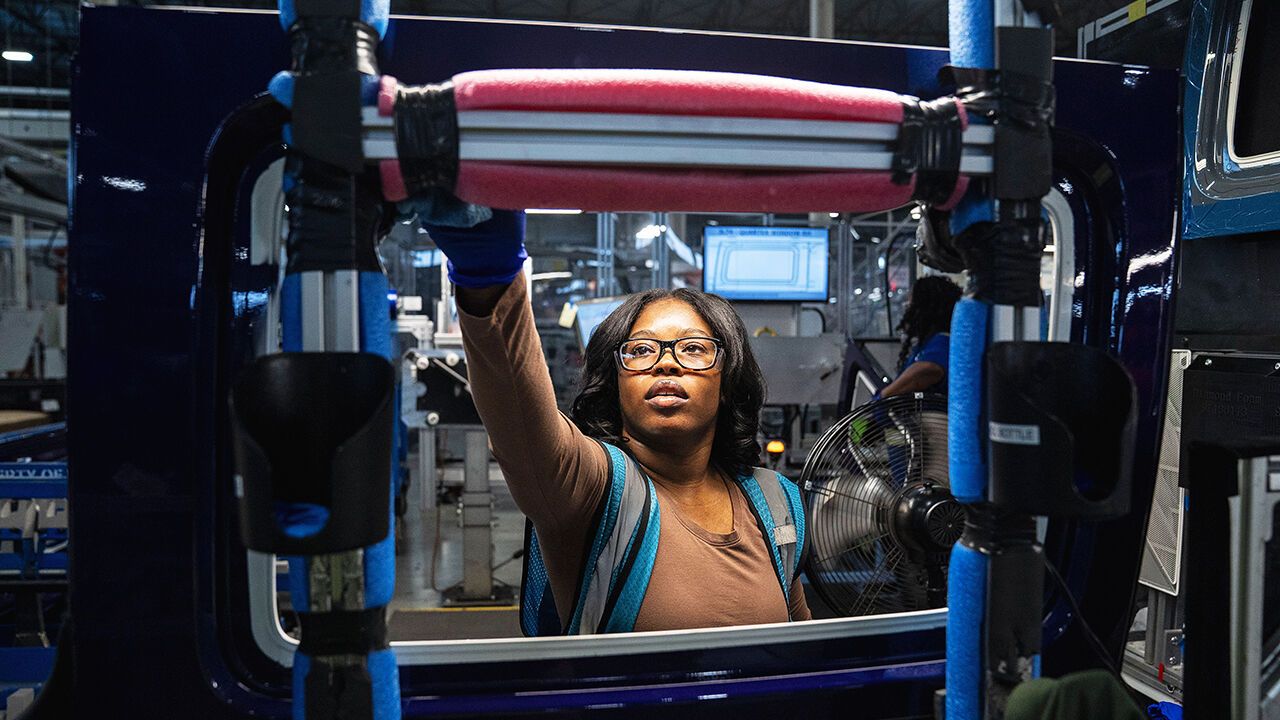 A worker inspects windows for convertible tops on the line at the Webasto Plymouth Plant in Michigan.
