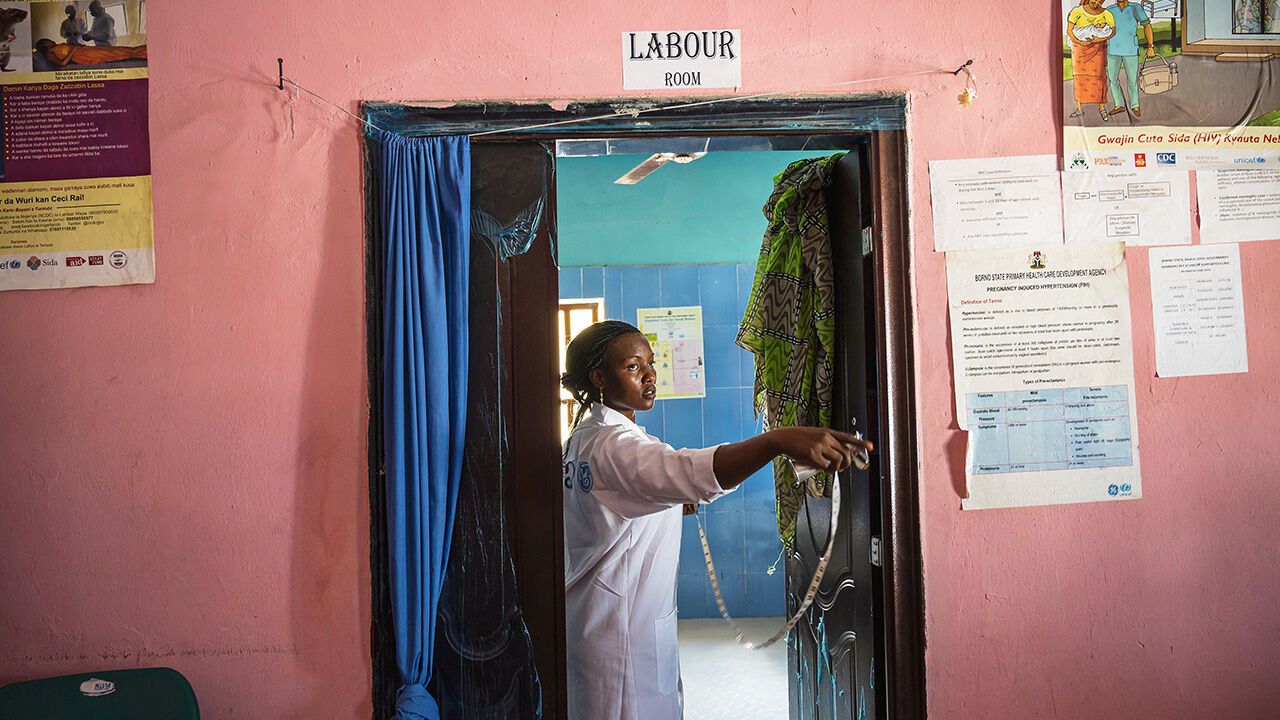 A midwife stands outside a labour ward in Nigeria