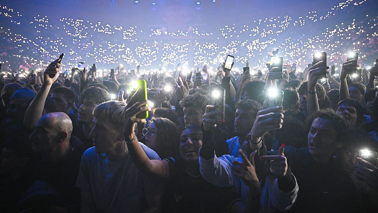 Fans hold smartphones during a concert.