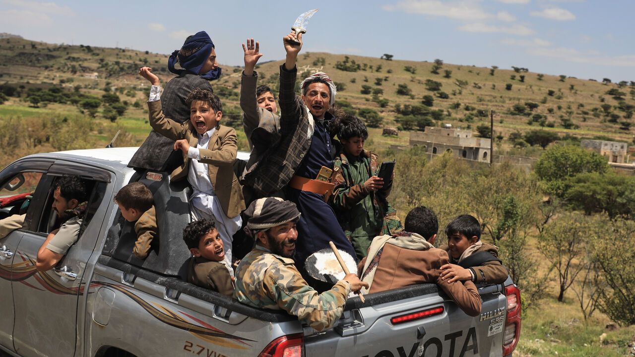 Yemeni civilians celebrate while riding in the back of a pickup truck in the Bani Matar district, Yemen.