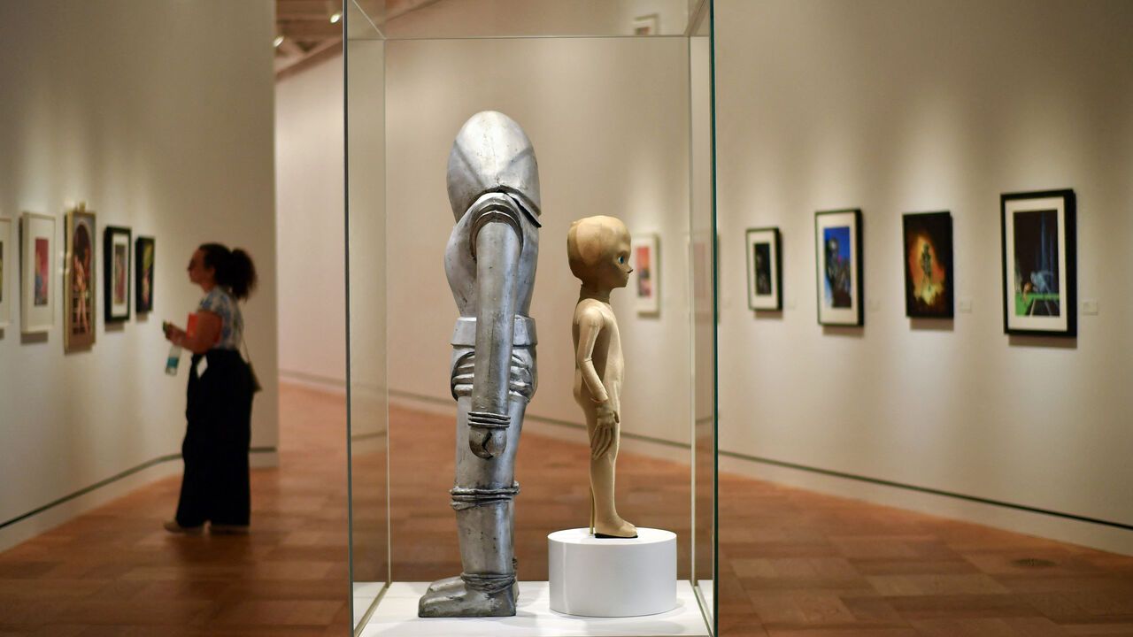 A visitor walks by costumes from Earth Versus the Flying Saucers at the Lucas Museum of Narrative Art
