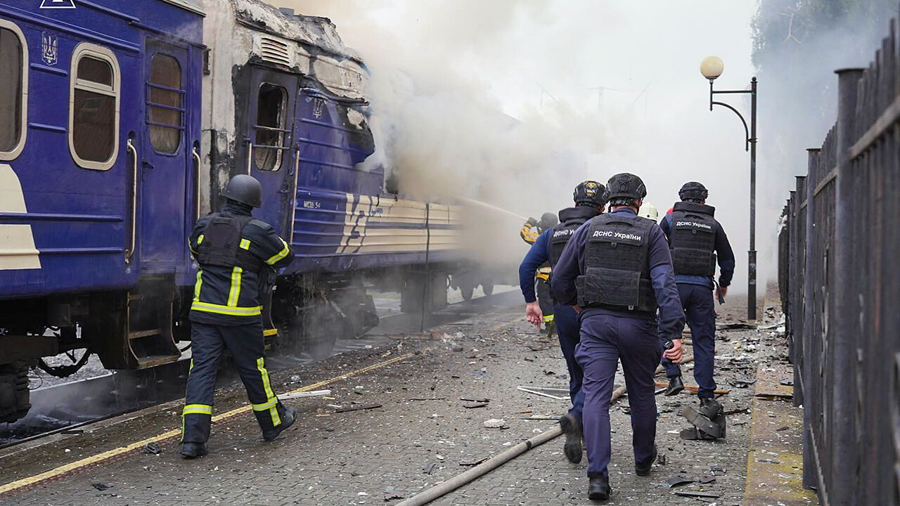 Firefighters extinguish fire at a train carriage damaged by a drone strike near the border with Poland, in Ukraine