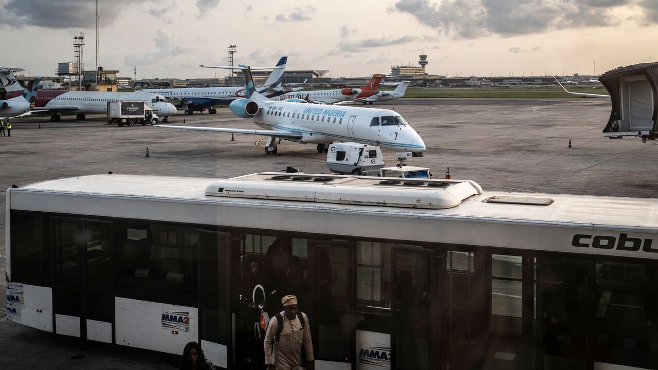 Passengers disembark a transport bus after thier arrival at Murtala Muhammed International Airport in Lagos.