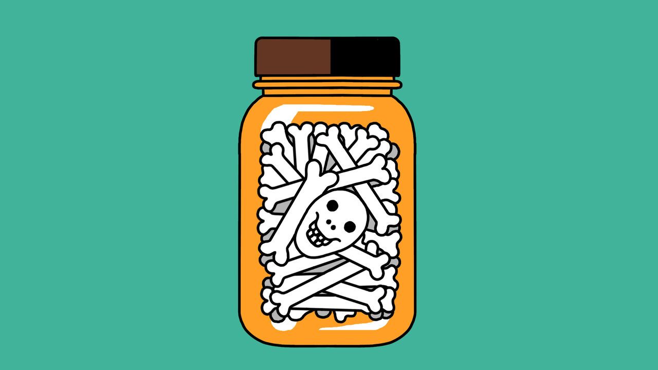 A medicine bottle filled with bones and a skull
