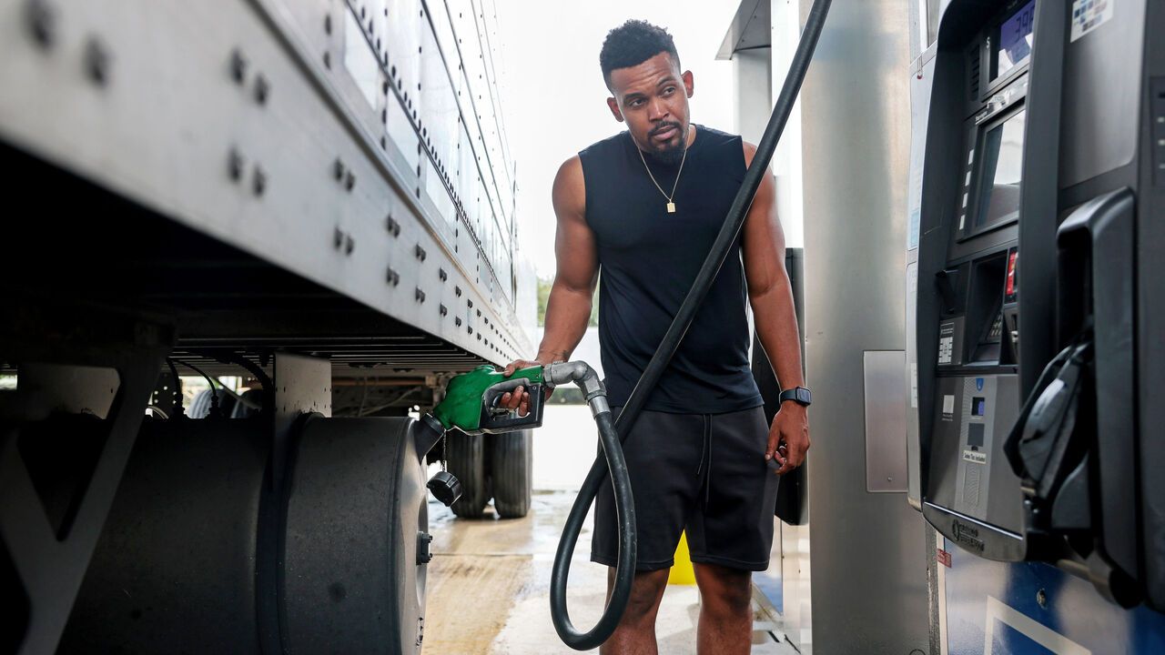 A man pumps diesel fuel into his tractor-trailer.