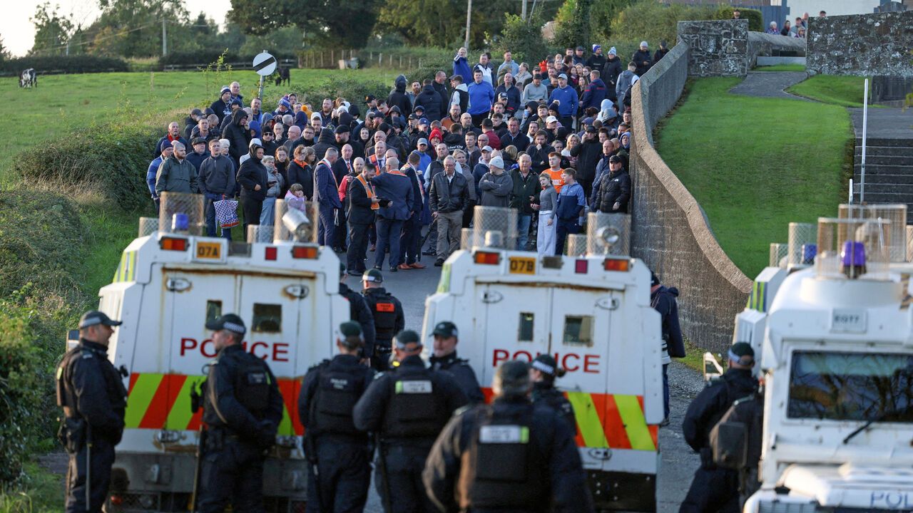 People taking part in the Protestant Orange Order's annual Drumcree parade gather as police block the road