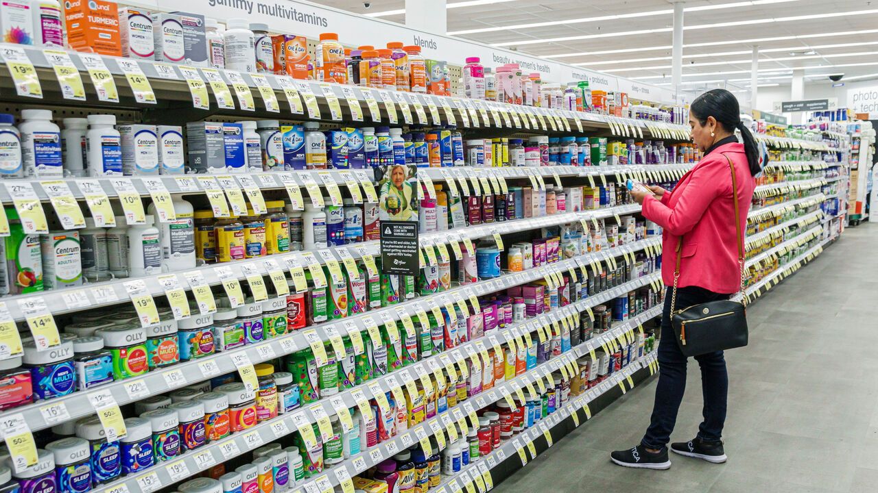 A woman looks at supplements in a pharmacy.