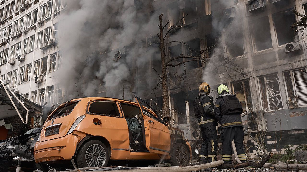Firefighters work to extinguish a fire at an office building following a strike by a Russian drone in Kyiv, Ukraine