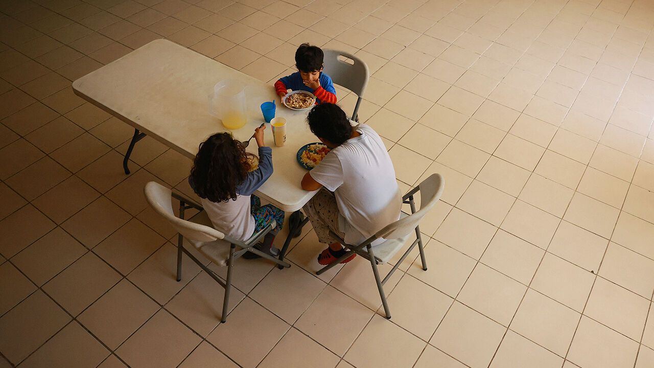 Ecuadorean migrants eat breakfast at the El Buen Samaritano shelter at Mexico's northern border