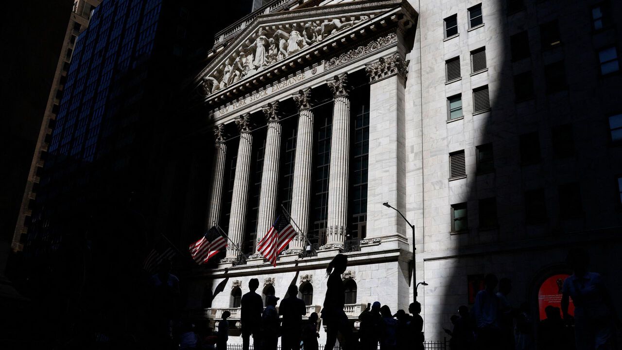 Pedestrians gather near the entrance to the New York Stock Exchange after the opening bell on Wall Street, New York City, USA.