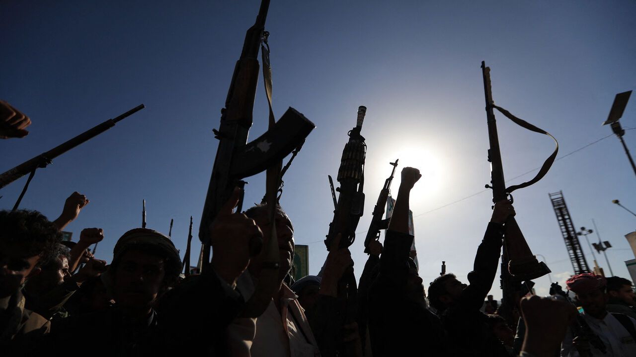Silhouettes of the supporters of the Houthi authorities brandish their weapons during a protest against Saudi intervention in Yemen, in Sanaa.