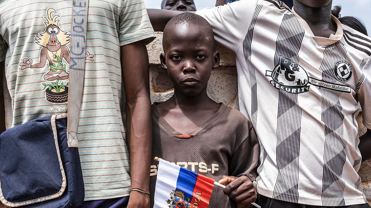 A young demonstrator holds Russian flag with the emblem of Russia on in Bangui, Central African Republic