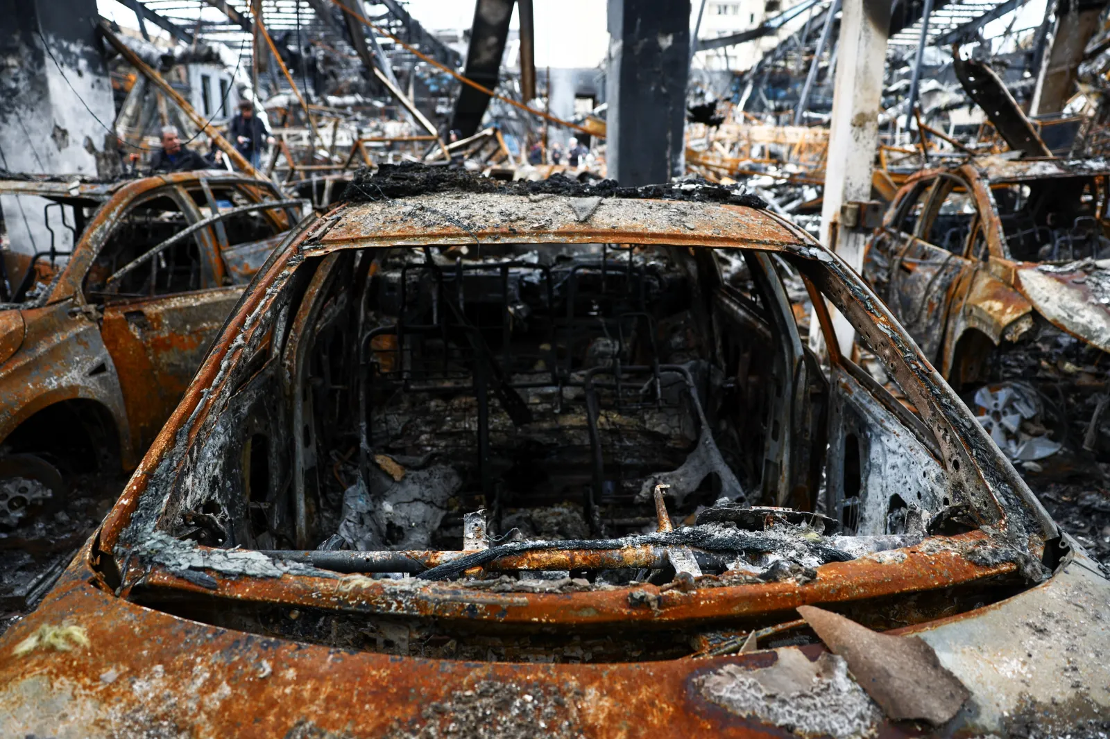 Burnt-out vehicles inside a car shop damaged by a strike, Tehran, March 2026