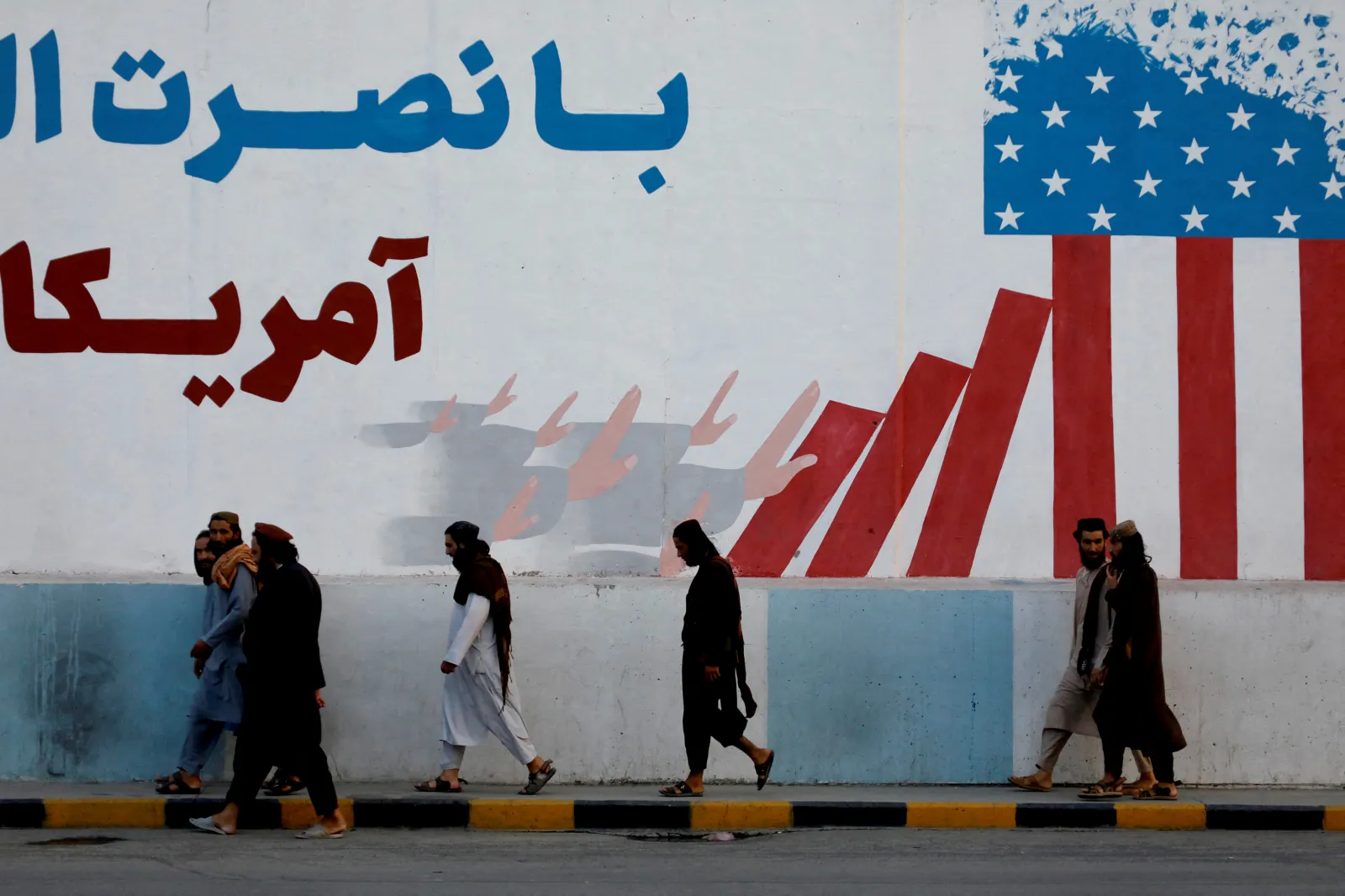 Taliban members walking past the former U.S. embassy in Kabul, Afghanistan, August 2022