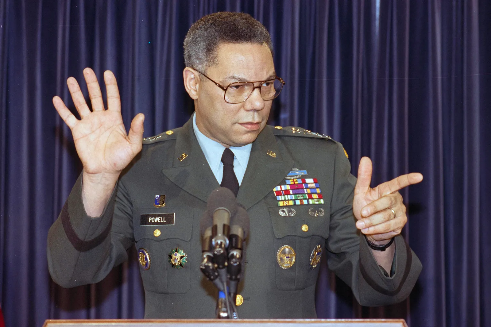 US Army general Colin Powell, Chairman of the Joint Chiefs of Staff, at Gulf War briefing. he is pointing to one reporter and gesturing with his other hand in a STOP mode. January 17, 1991