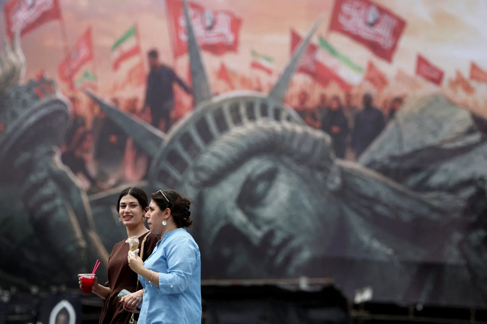 Walking past an anti-U.S. billboard in Tehran, Iran, August 2026